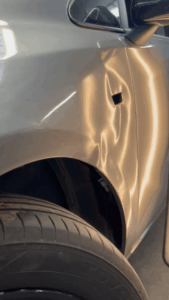 Grave ammaccatura su parafango auto prima della riparazione levabolli PDR