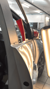 Portiera auto con danni da grandine prima della riparazione levabolli PDR